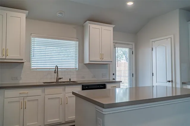 a kitchen with stainless steel appliances granite countertop a sink and a white cabinets