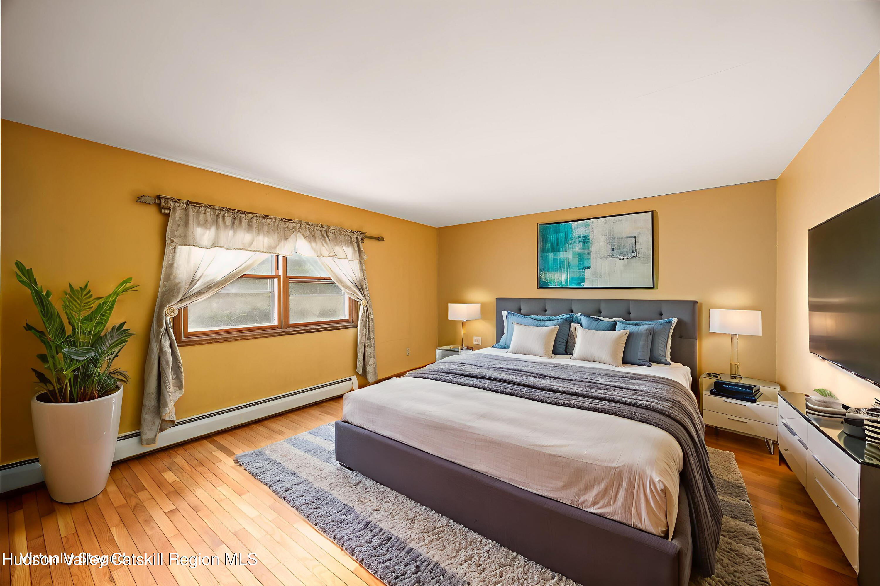 94 Tanglewood Road West Hurley, NY 12491 - Photo 17 of 34 a bedroom with a large bed and a potted plant