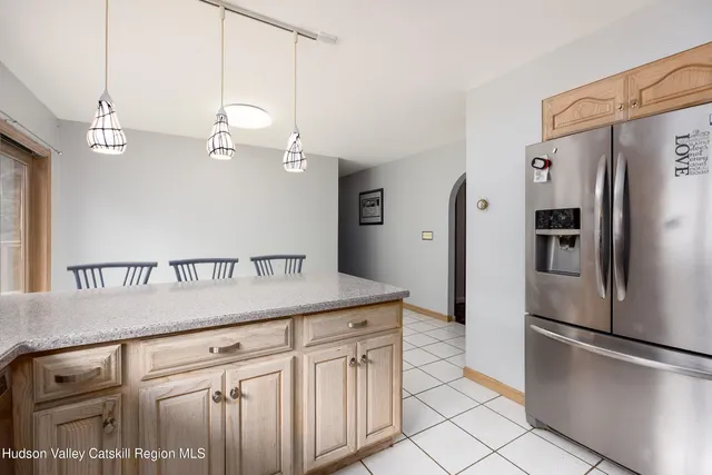 a kitchen with kitchen island a counter top a refrigerator and a sink