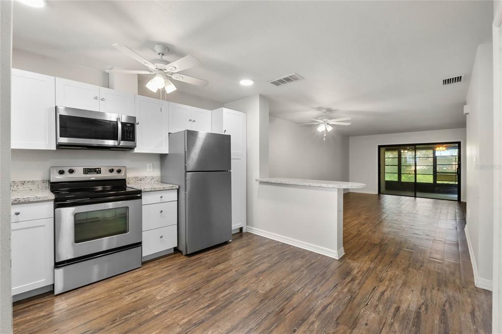 2723 Beacon Street Eustis, FL 32726 - Photo 11 of 42 a kitchen with stainless steel appliances a stove a refrigerator and a microwave