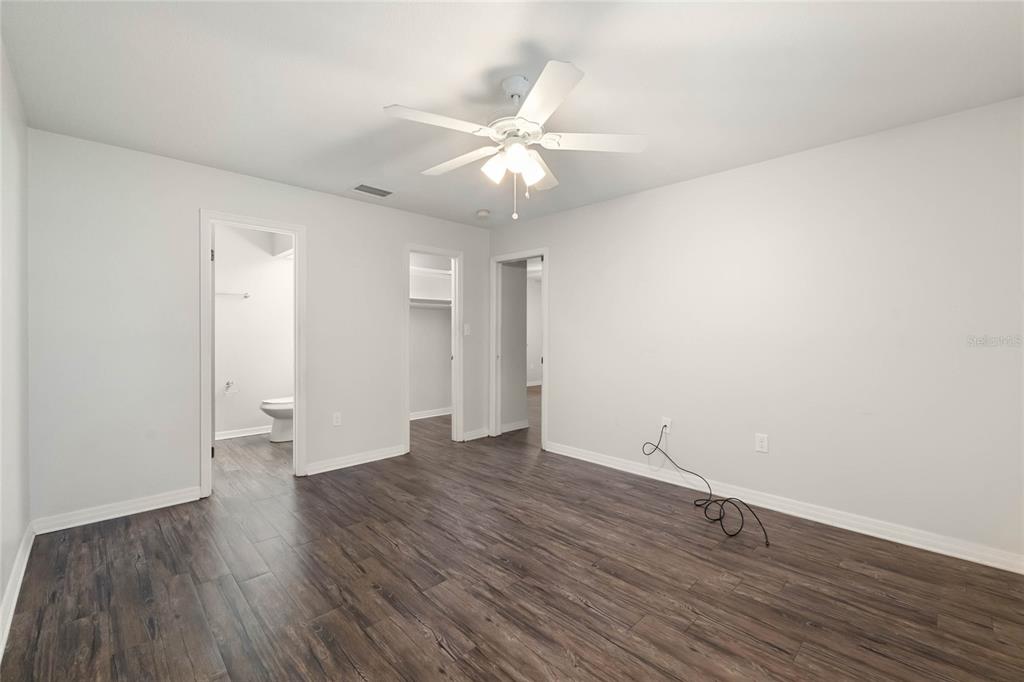 2723 Beacon Street Eustis, FL 32726 - Photo 16 of 42 a view of an empty room with wooden floor and a ceiling fan