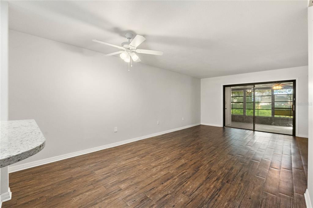 2723 Beacon Street Eustis, FL 32726 - Photo 6 of 42 an empty room with wooden floor fan and windows