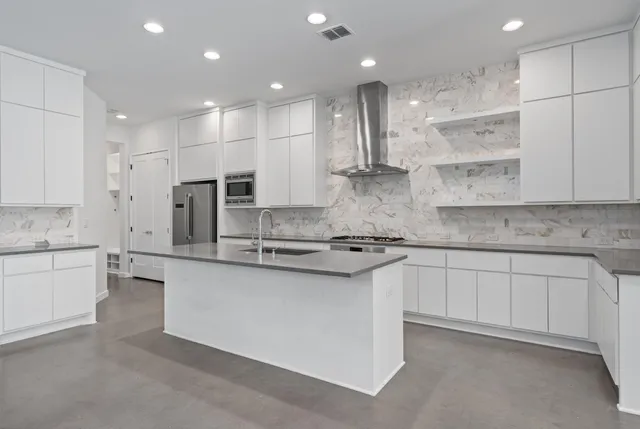 a kitchen with stainless steel appliances granite countertop a white stove top oven a sink and white cabinets