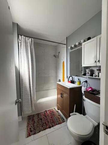 a bathroom with a bathtub shower sink vanity and toilet