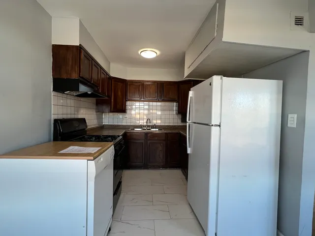 a kitchen with stainless steel appliances granite countertop a refrigerator a stove a sink and a microwave