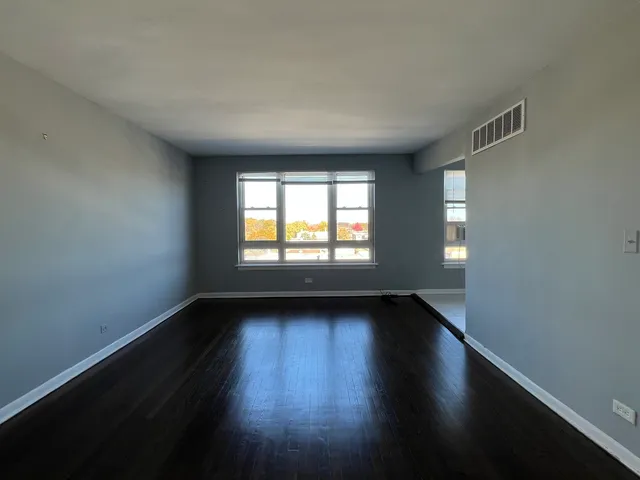 a view of an empty room window and wooden floor