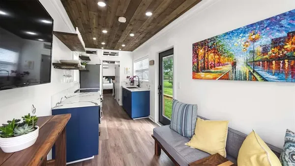 a kitchen with stainless steel appliances wooden floor dining table and chairs
