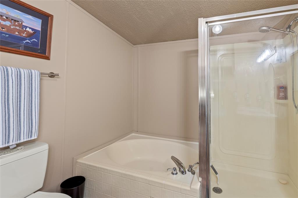 194 Indian Gap Road Mabank, TX 75156 - Photo 11 of 18 a bathroom with a bathtub and a shower
