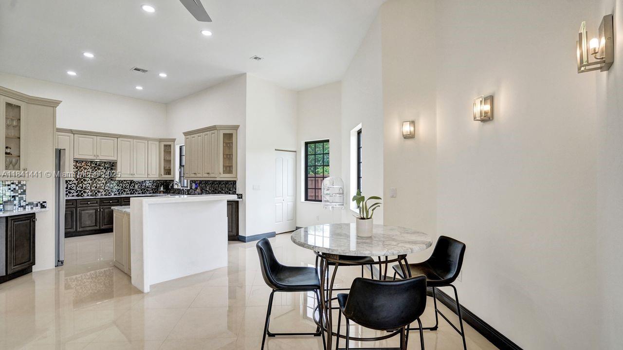 3311 Southwest 118th Terrace Davie, FL 33330 - Photo 24 of 95 a kitchen with a dining table chairs sink and cabinets