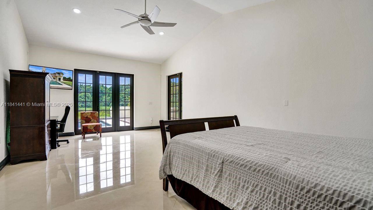 3311 Southwest 118th Terrace Davie, FL 33330 - Photo 45 of 95 a bedroom with a bed a ceiling fan and a large window