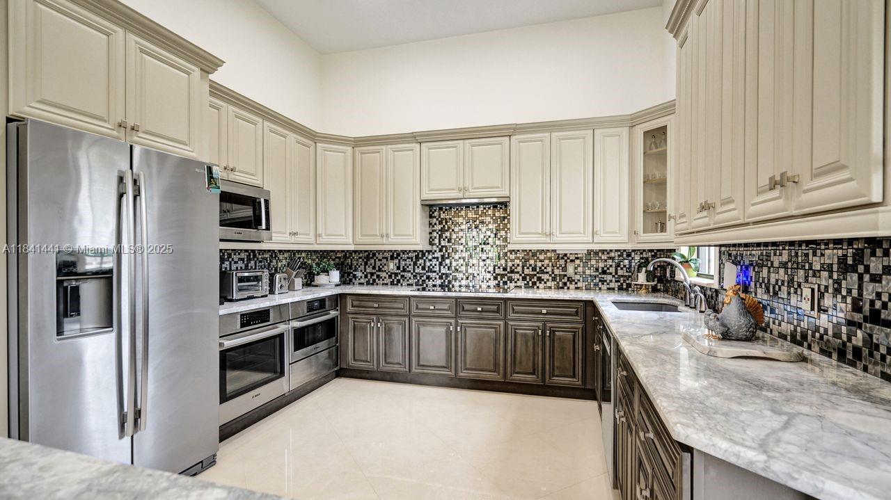 3311 Southwest 118th Terrace Davie, FL 33330 - Photo 9 of 95 a kitchen with stainless steel appliances granite countertop a sink stove and refrigerator