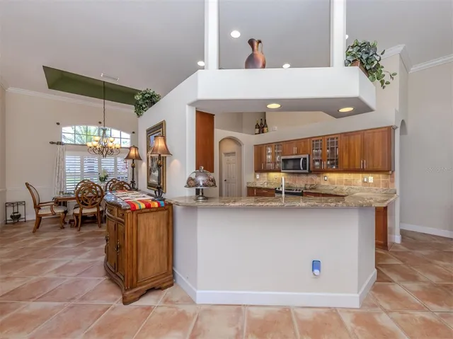 a view of dining room kitchen with stainless steel appliances granite countertop a sink and cabinets