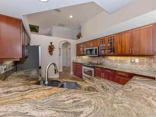 a kitchen with stainless steel appliances granite countertop a stove a sink and a microwave