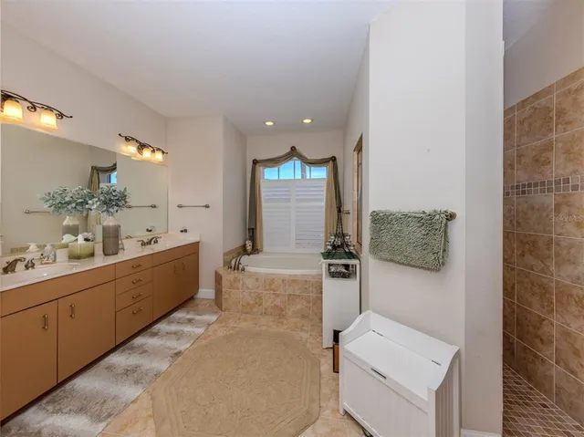 a large bathroom with a tub sink and mirror