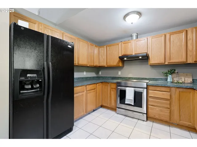 a kitchen with stainless steel appliances granite countertop a refrigerator and a sink