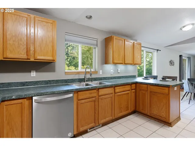 a kitchen with granite countertop a sink window and cabinets
