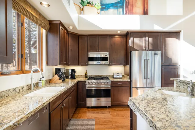 a kitchen with stainless steel appliances granite countertop a refrigerator and a stove