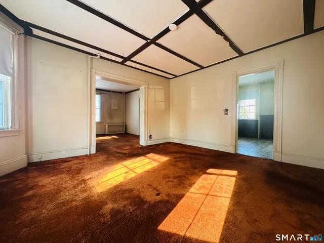a view of a big room with wooden floor and brick walls