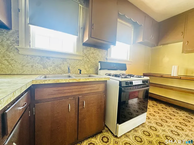 a kitchen with stainless steel appliances granite countertop a sink stove and cabinets