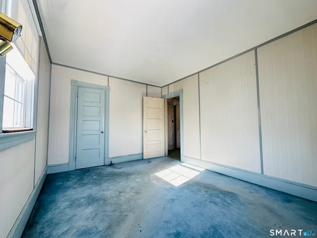 an empty room with windows and closet