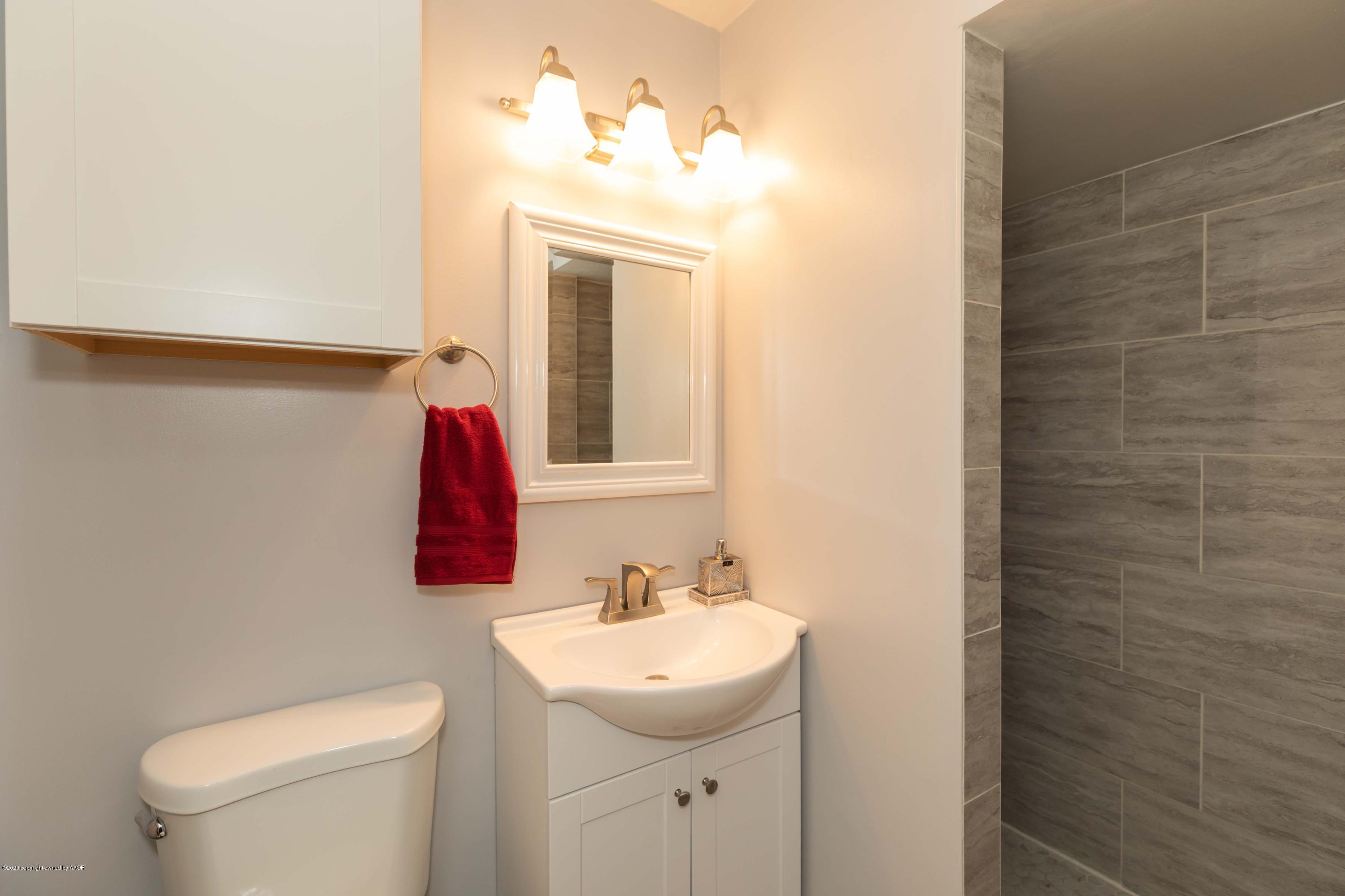 4712 South Bryan Street Amarillo, TX 79110 - Photo 21 of 36 a bathroom with a sink and a mirror