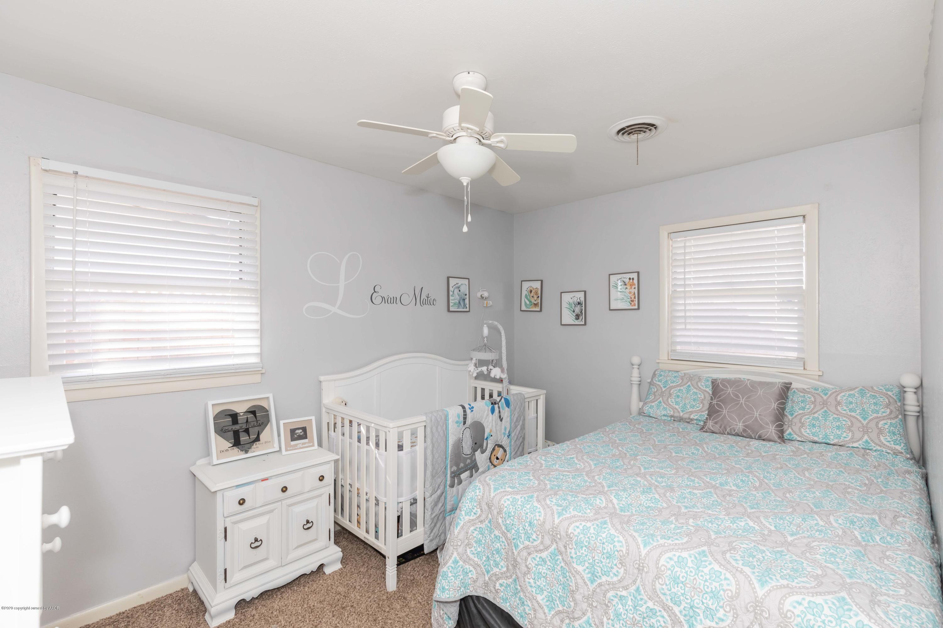 4712 South Bryan Street Amarillo, TX 79110 - Photo 27 of 36 a bedroom with a bed and a chandelier