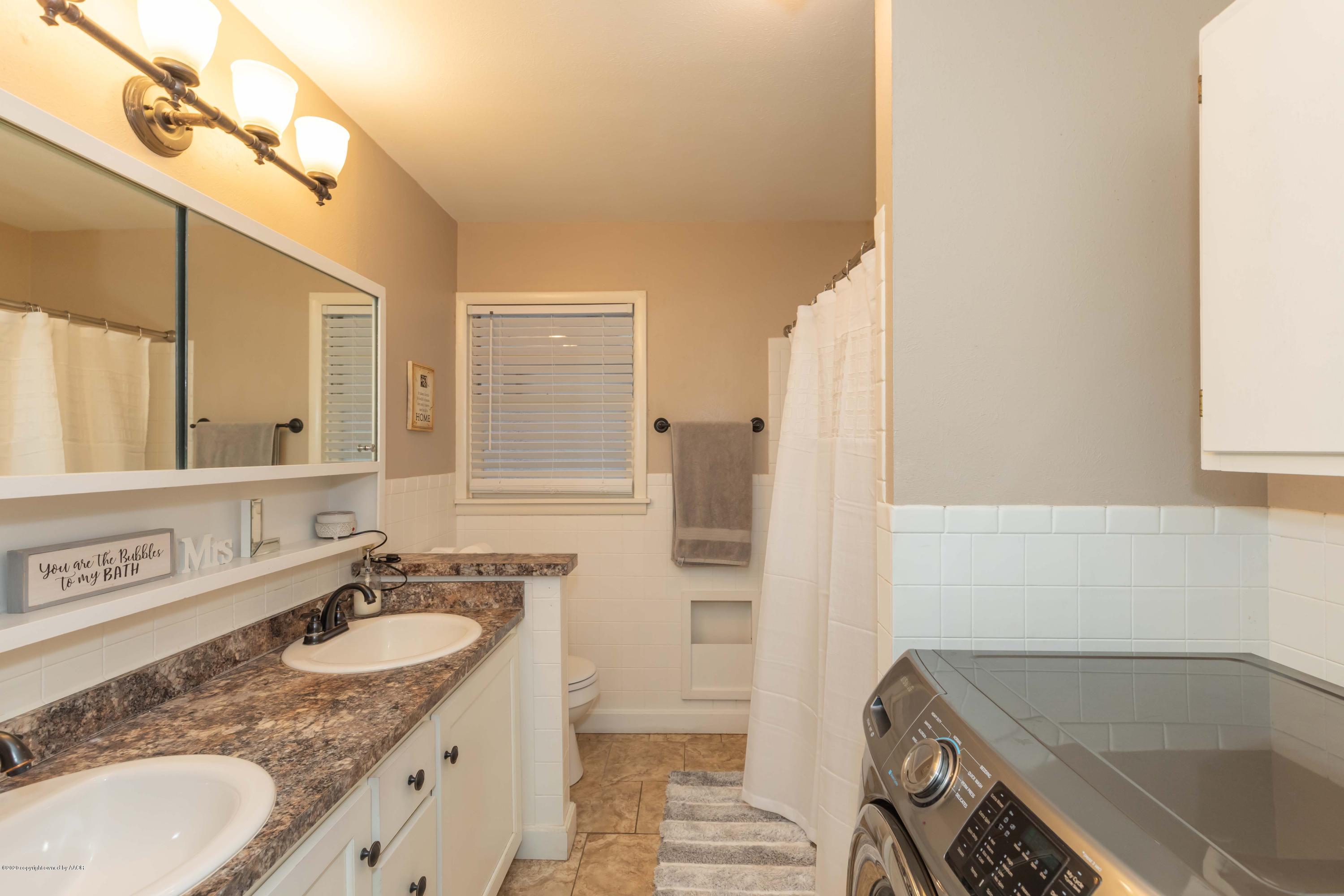 4712 South Bryan Street Amarillo, TX 79110 - Photo 29 of 36 a bathroom with a granite countertop sink and a bathtub