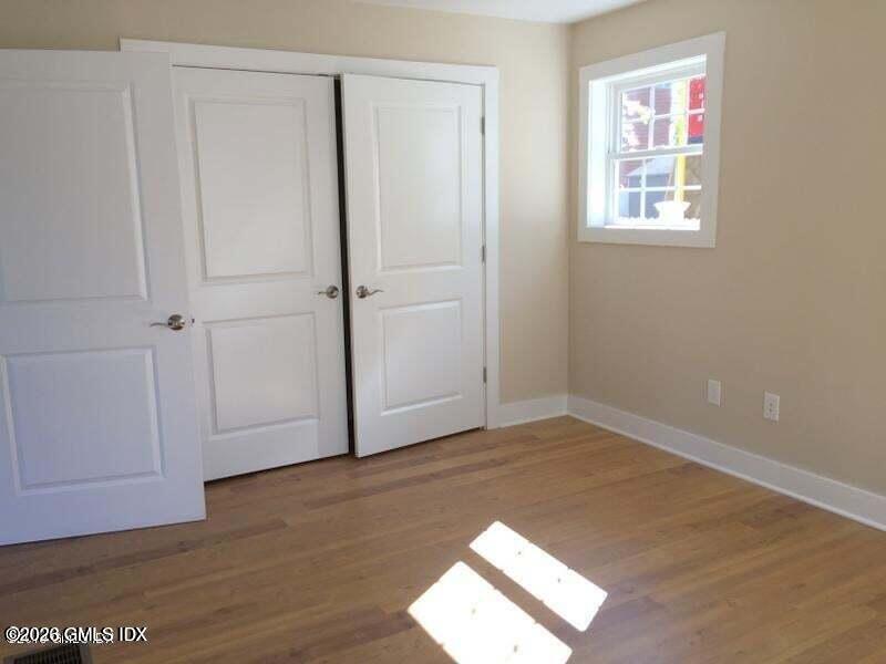 180 Hamilton Avenue, Unit C Greenwich, CT 06830 - Photo 11 of 15 an empty room with wooden floor and windows