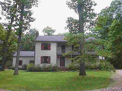 a view of a big yard in front of a house with a large tree