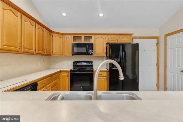 a kitchen with stainless steel appliances kitchen island granite countertop a refrigerator stove and microwave