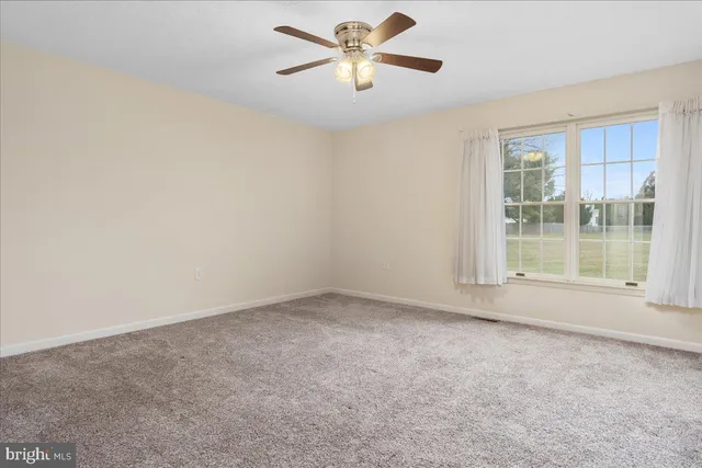 a view of empty room with ceiling fan