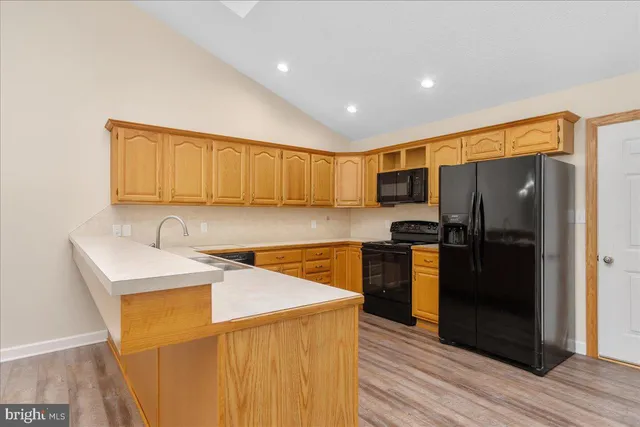 a kitchen with a sink a refrigerator and cabinets