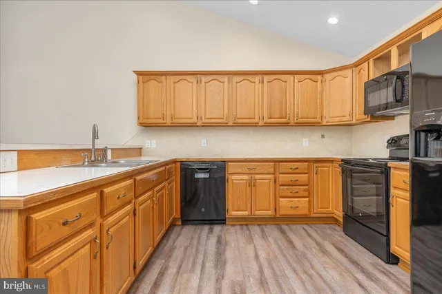 a kitchen with granite countertop wooden cabinets a sink and dishwasher