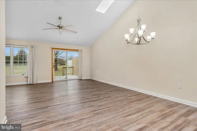 a view of empty room with wooden floor and window