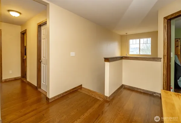 a view of a hallway with living room and wooden floor