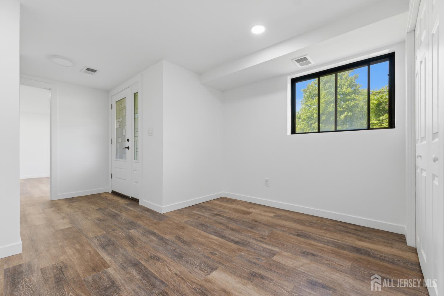 12 Daniel Road Spotswood, NJ 08884 - Photo 17 of 27 an empty room with wooden floor and windows