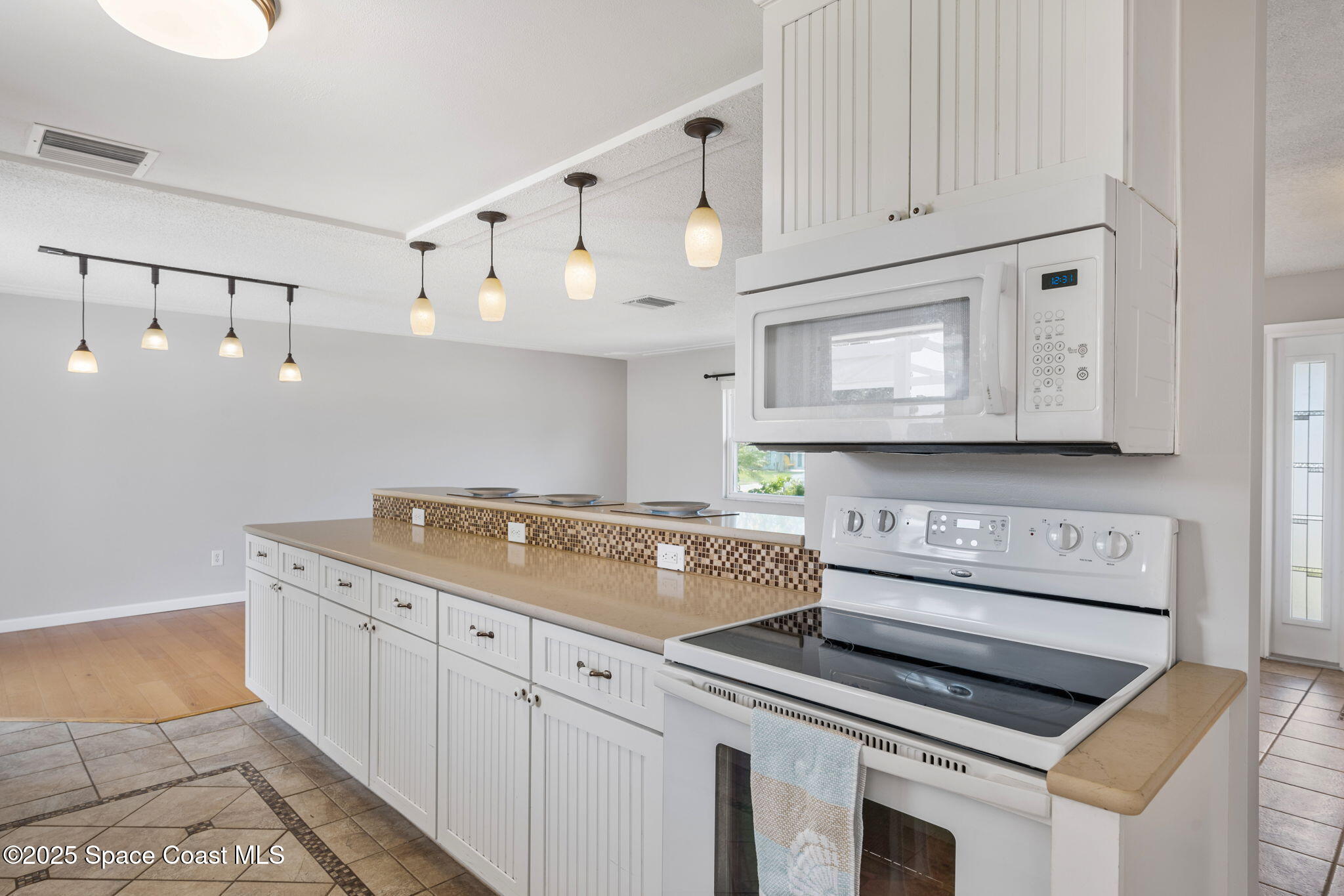 437 Eagle Drive Satellite Beach, FL 32937 - Photo 10 of 30 a kitchen with granite countertop a stove sink and cabinets