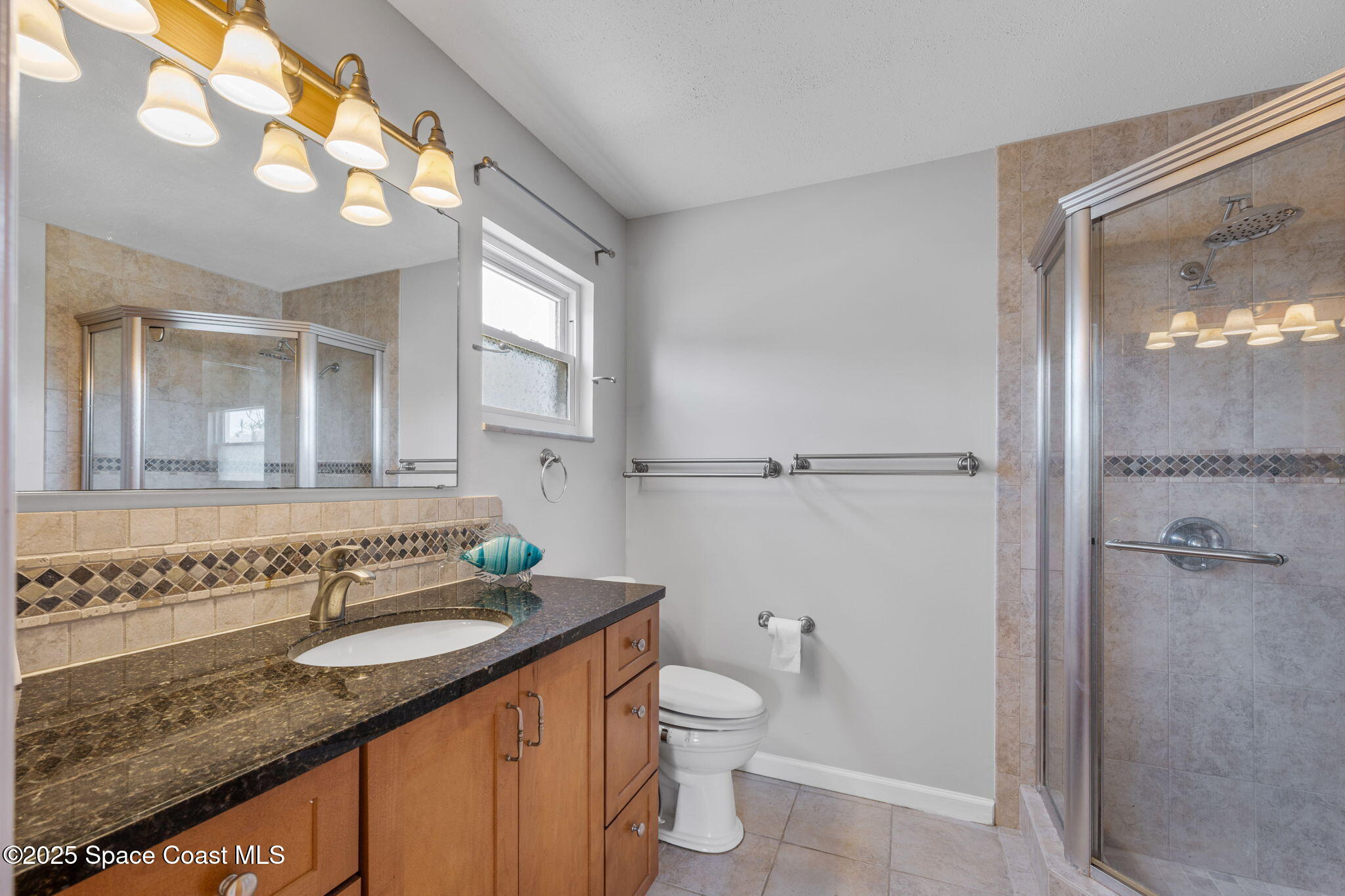 437 Eagle Drive Satellite Beach, FL 32937 - Photo 18 of 30 a bathroom with a granite countertop sink toilet and shower