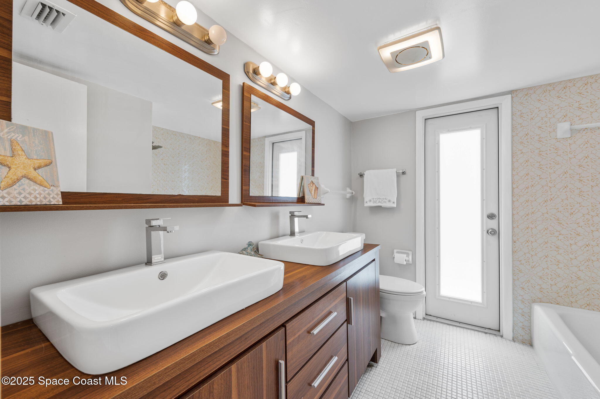 437 Eagle Drive Satellite Beach, FL 32937 - Photo 20 of 30 a bathroom with a sink a toilet and mirror