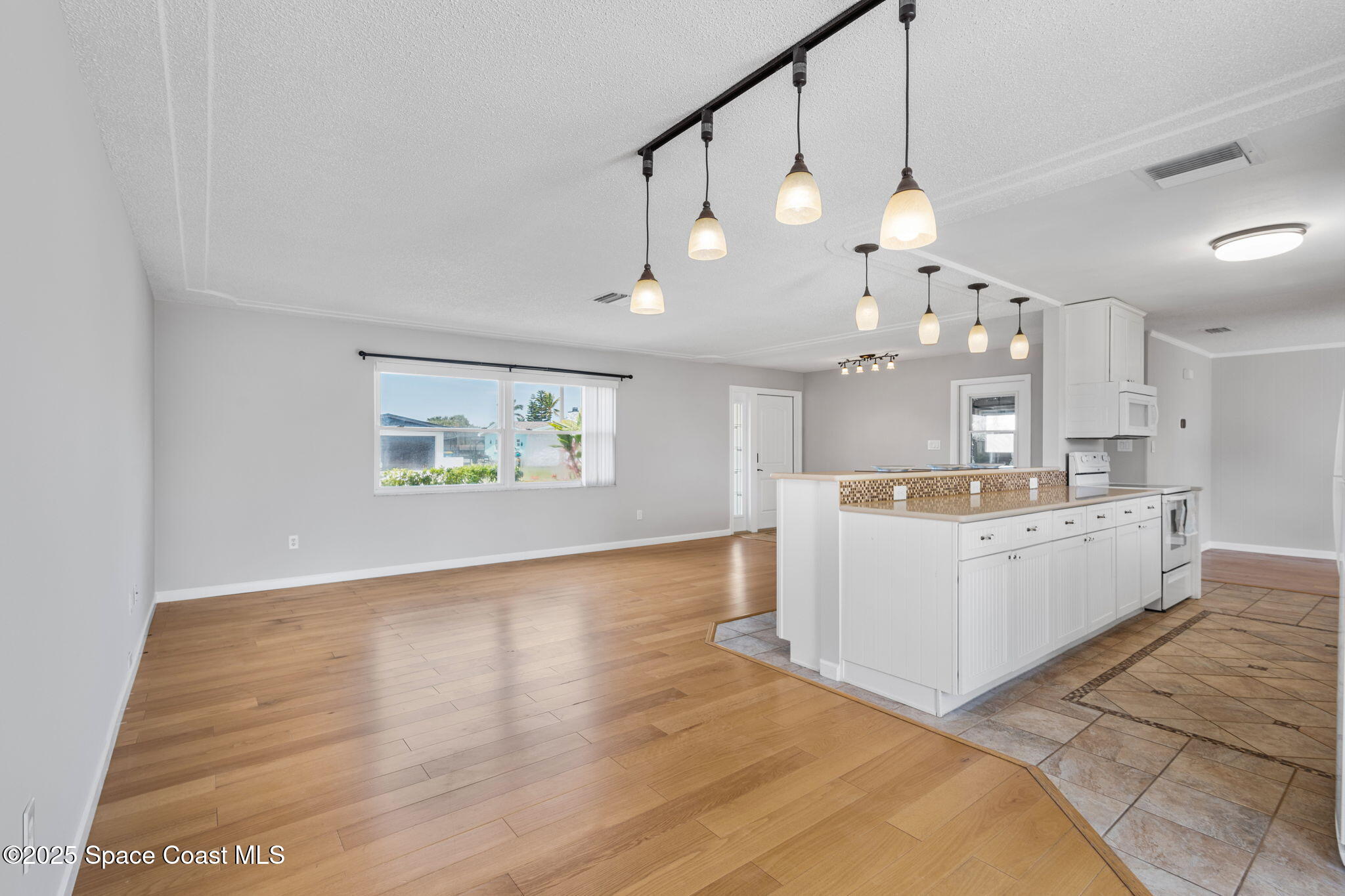 437 Eagle Drive Satellite Beach, FL 32937 - Photo 7 of 30 a view of a kitchen with a sink dishwasher a kitchen island with wooden floor