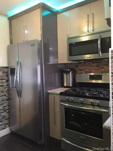 a kitchen with granite countertop a stove and a microwave