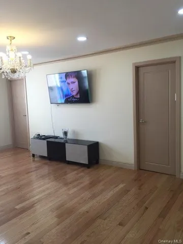 an empty room with wooden floor and cabinet