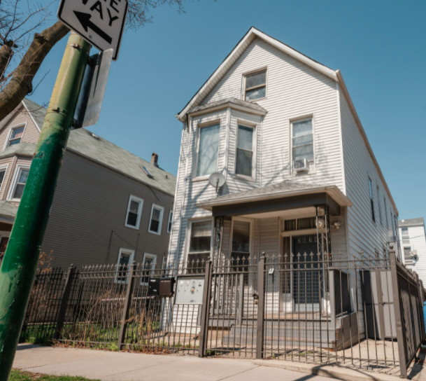 a view of a white house with iron fence