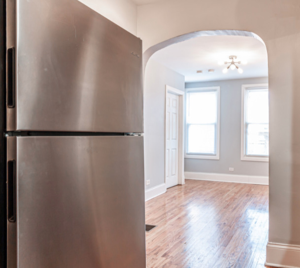 3614 West George Street, Unit 1R Chicago, IL 60618 - Photo 11 of 12 an empty room with wooden floor fan and windows