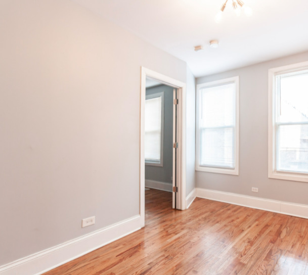 3614 West George Street, Unit 1R Chicago, IL 60618 - Photo 9 of 12 an empty room with wooden floor and windows