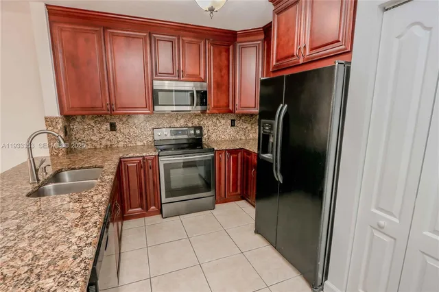 a kitchen with stainless steel appliances granite countertop a stove sink and cabinets