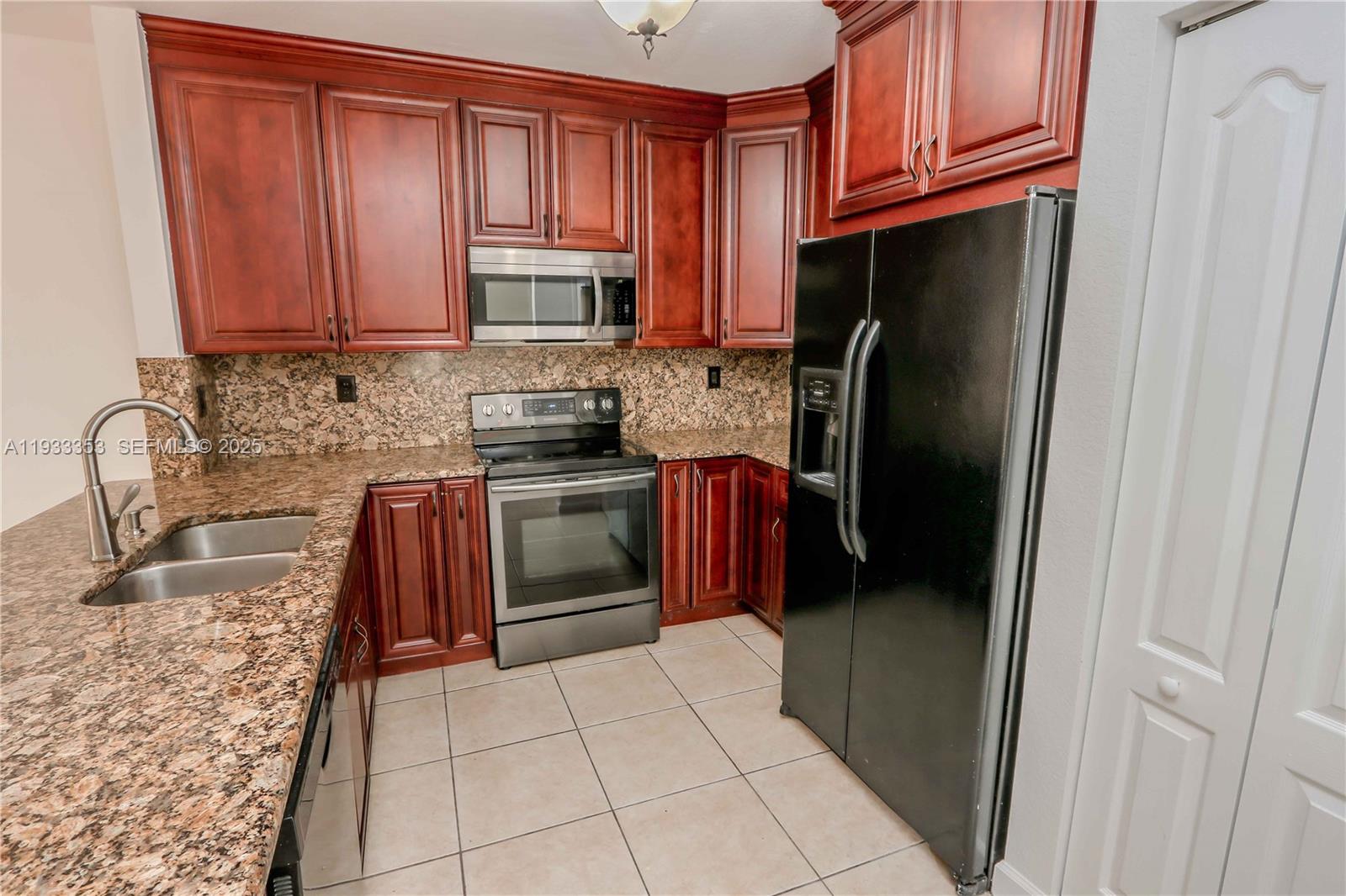 846 Southwest 148th Place Miami, FL 33194 - Photo 12 of 32 a kitchen with stainless steel appliances granite countertop a refrigerator stove and sink