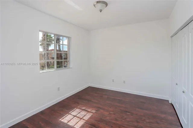 an empty room with wooden floor and closet
