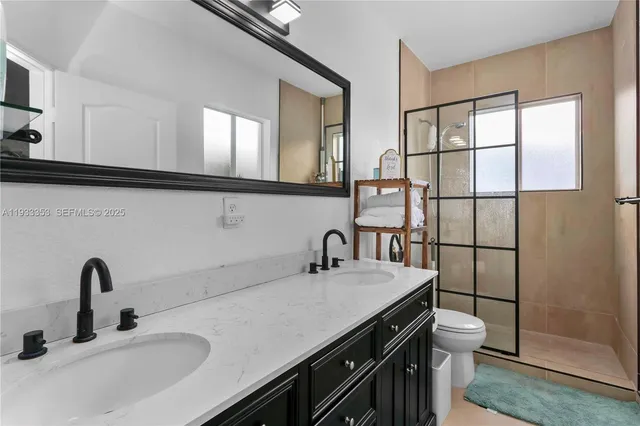 an empty room with wooden floor chandelier fan and windows