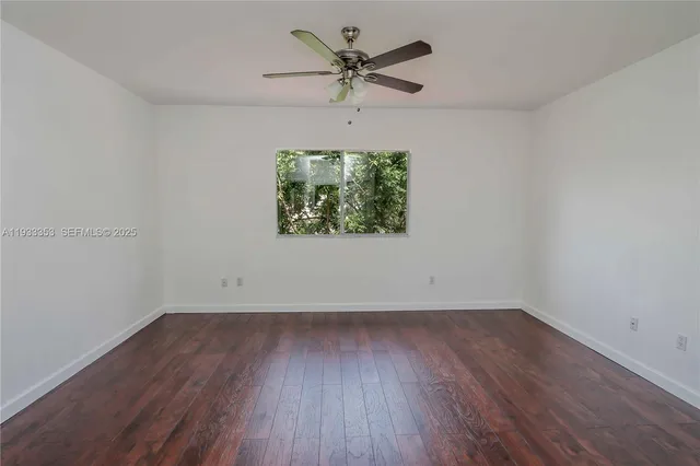 a view of a livingroom with wooden floor and a ceiling fan